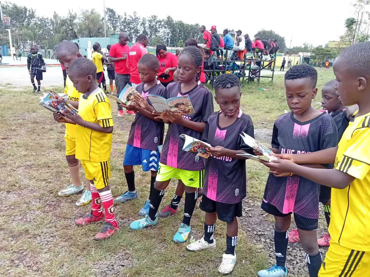 Youth players huddled together with coaches on a training ground in Kenya