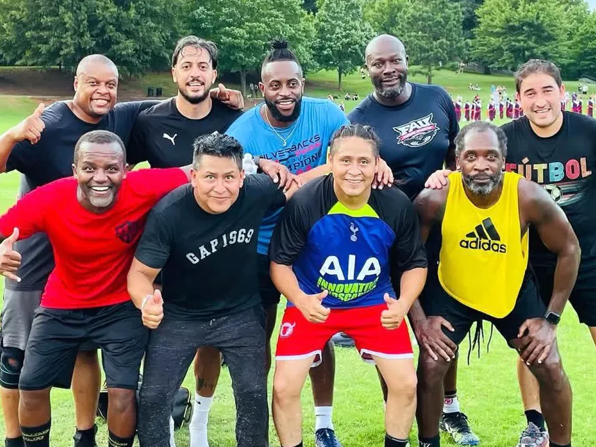 A diverse group of players celebrating together on a green field
